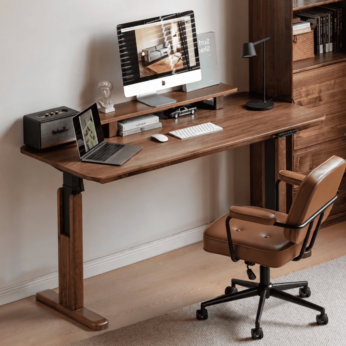 Prunus natural solid walnut electric height adjustable computer desk styled in a warm home office with monitor and office chair