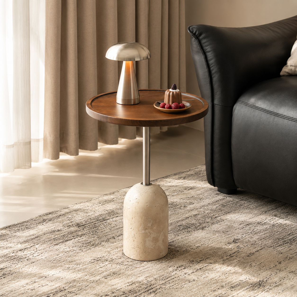 Round walnut side table with a travertine base and slim metal stem beside a black leather sofa.
