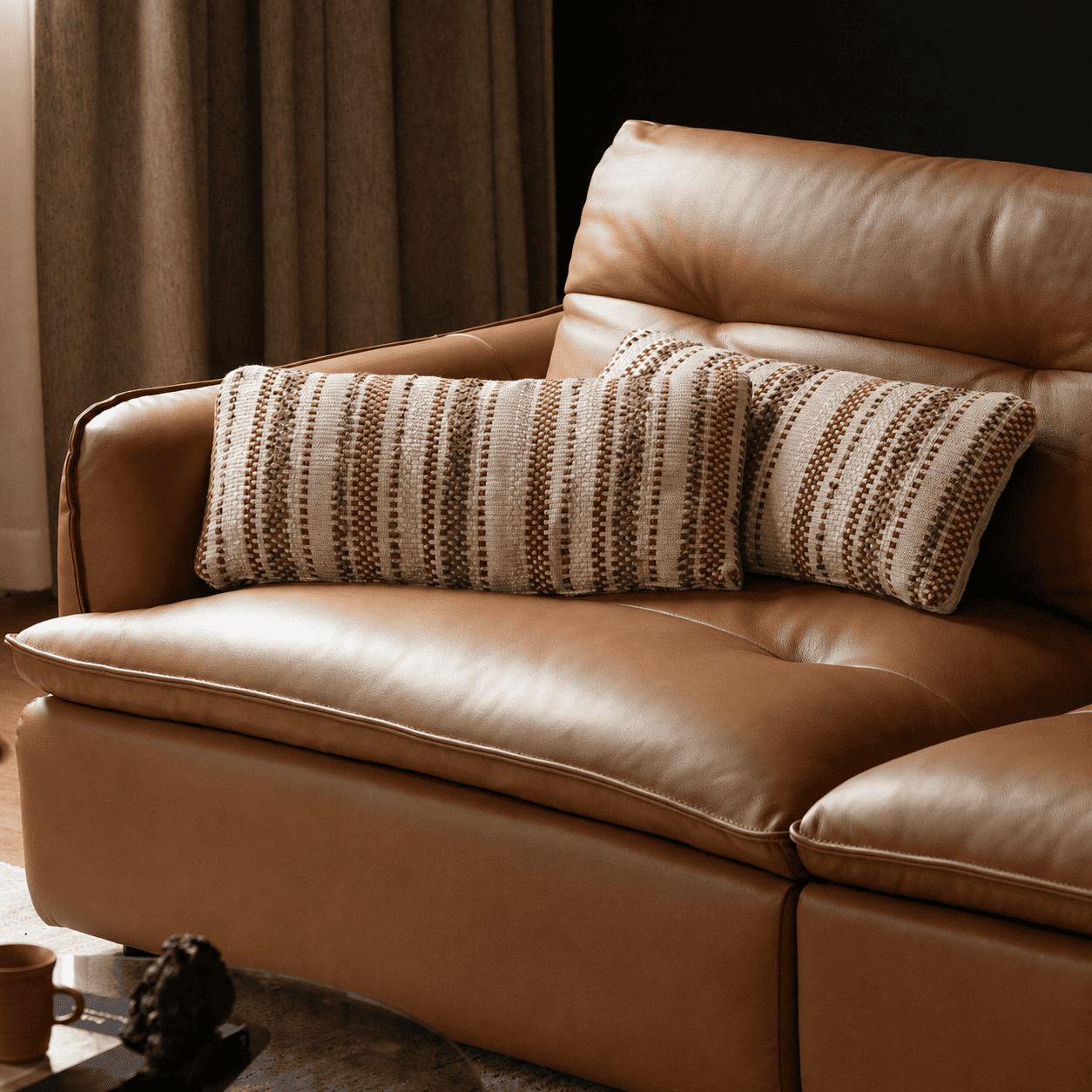 Tacoma leather sofa detail with brown striped lumbar cushions and plush seat padding