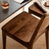Natural walnut dining chair with tapered legs and minimalist backrest design