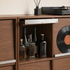 Close-up of natural walnut wood grain and rounded edges on a modular storage cabinet.
