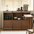 Wide walnut modular media cabinet with record storage and open shelving in a modern living room.