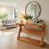 Natural oak hallway table styled with lamp, vase, books, and indoor plants