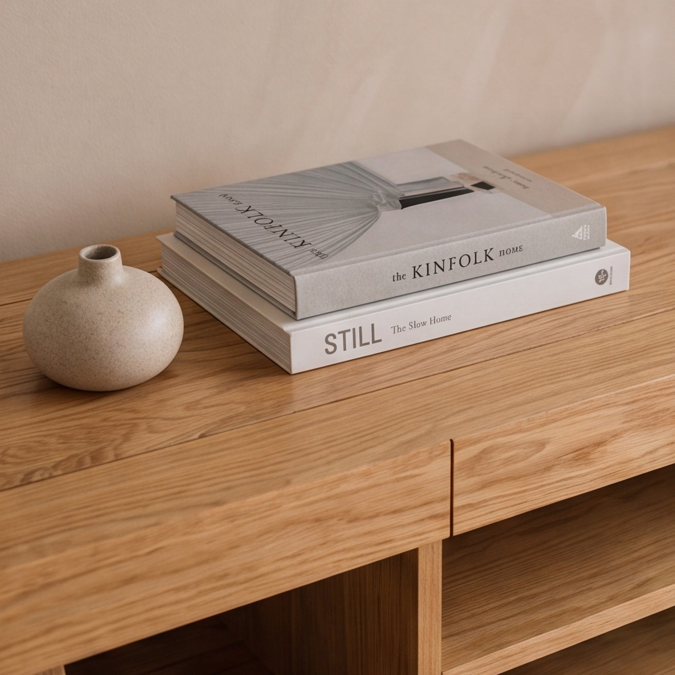 Solid oak entertainment unit paired with wall-mounted television, floor lamp, and indoor plants