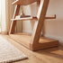 Natural solid oak shelving unit paired with leather armchair and indoor plant in a cosy lounge