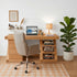 Natural oak work station styled with laptop, table lamp, books, and indoor plants